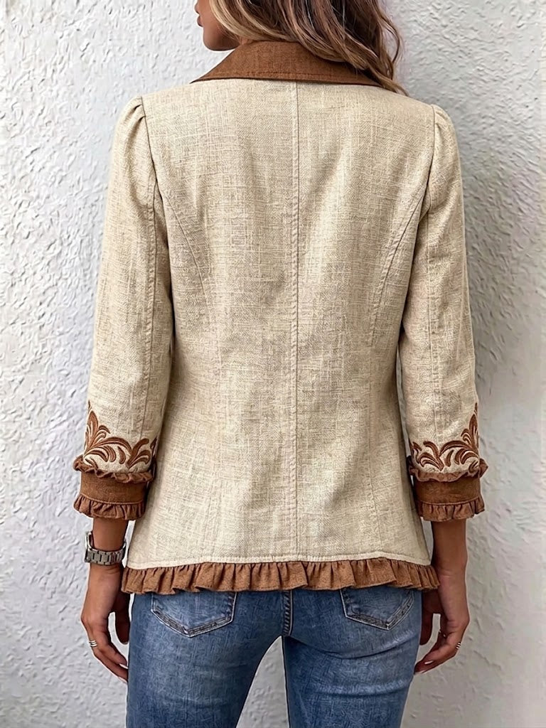 Beige vintage jacket back view with brown embroidered cuffs and scalloped hem