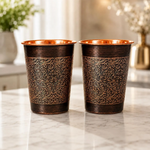 Pair of copper mugs with golden floral scrollwork on dark bronze sides and copper tops