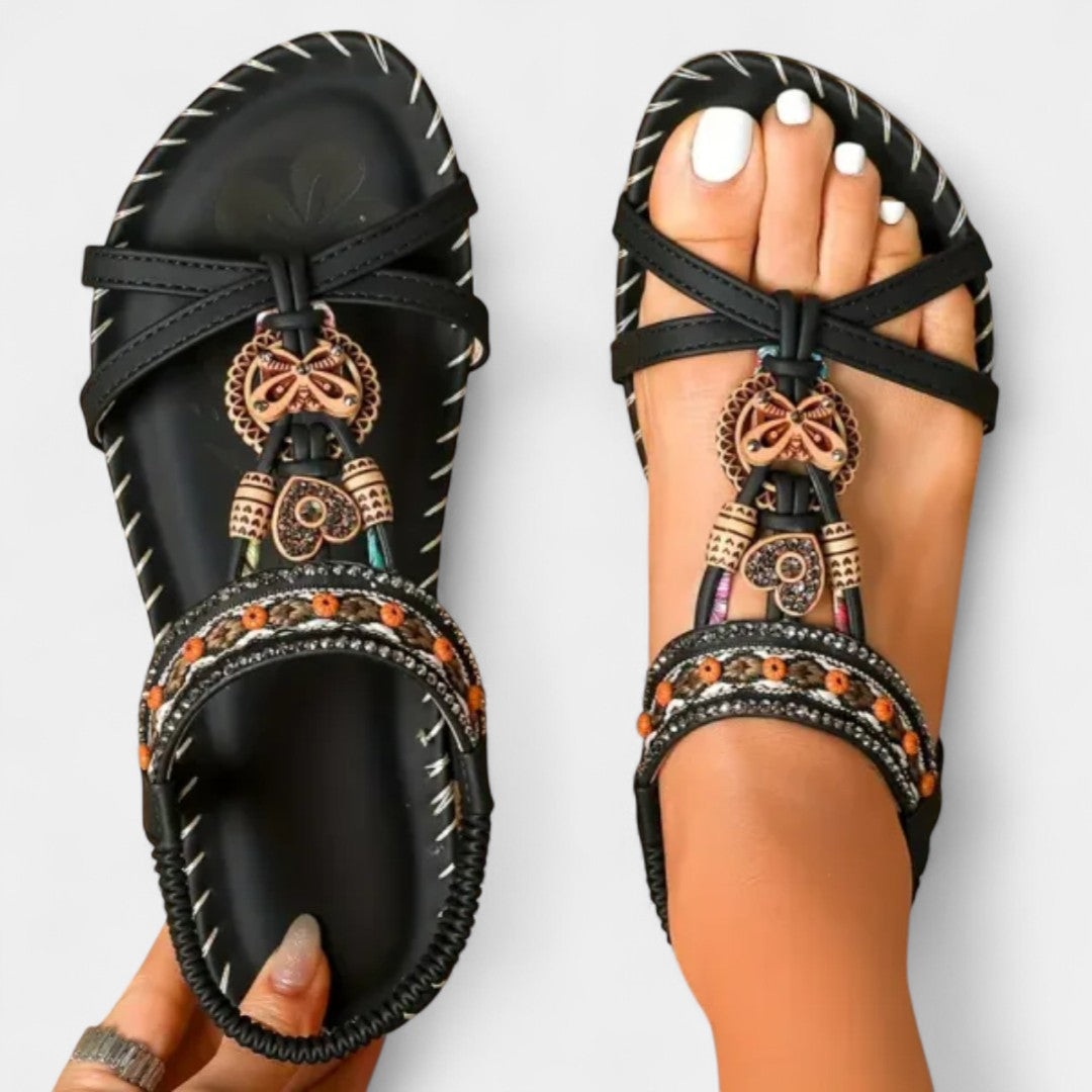 Black orthopedic sandals with toe loop straps and ornate charm bead trim