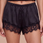 Women's dark satin shorts with elastic waistband and lace hem trim.