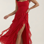 Red elegant dress with thin straps, ruffled detailing, and flowing asymmetrical skirt