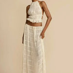 White pleated halter crop top with ruffled tiers, styled with a long tiered skirt