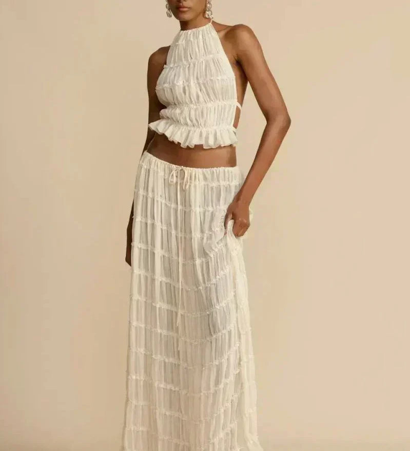 White pleated halter crop top with ruffled tiers, styled with a long tiered skirt