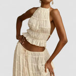 White pleated halter crop top with ruffled tiers and no back coverage