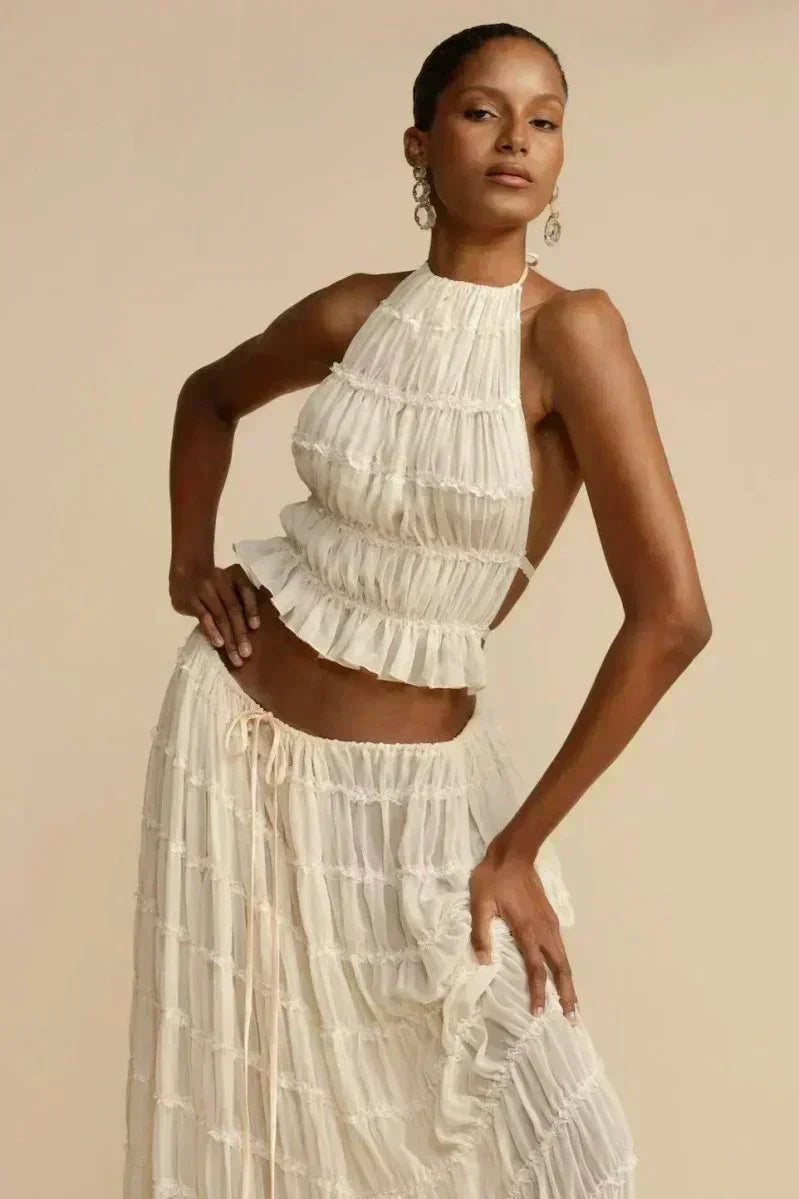 White pleated halter crop top with ruffled tiers and open back, front view