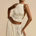 White pleated halter crop top with ruffled tiers and open back, front view