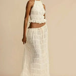 White pleated halter crop top with ruffled tiers, sleeveless cut