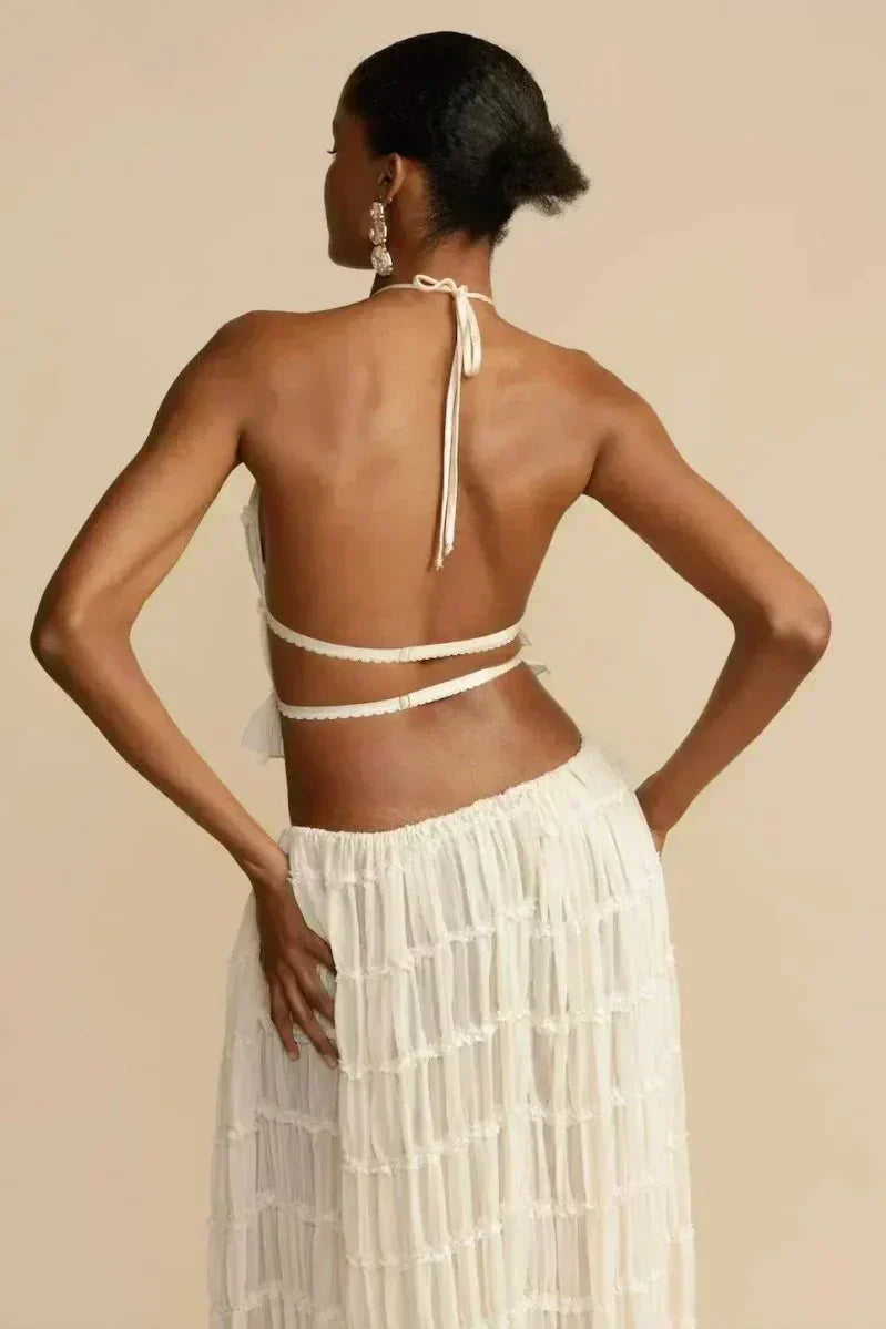 White pleated backless halter crop top with tie straps on the open back