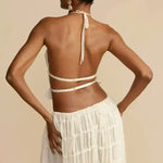White pleated backless halter crop top with tie straps on the open back