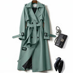 Mint green classic trench coat with belted waist, dark button details, and epaulets
