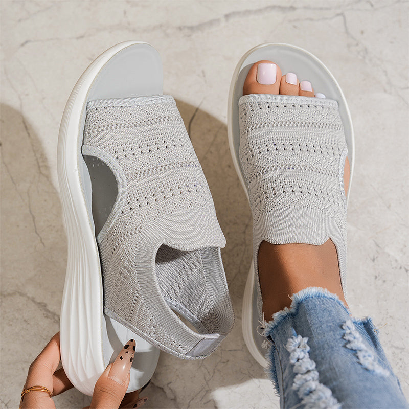 Beige knit platform slide sandals with wide cutout upper and textured strap design.