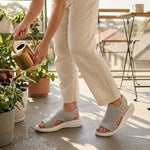 Cream knit open-toe slide sandals with cushioned white sole and side cutouts.