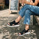 Black open-toe knit platform slide sneakers with white midsoles.