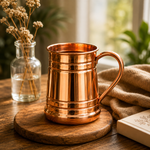 Copper mug with handle and ridged body, on a round wooden base