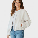 White cropped bomber jacket with full front zipper, side pockets, and elastic cuffs