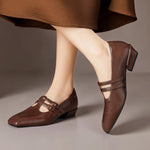 Brown Mary Jane loafers with two strap buckles and broguing perforation pattern
