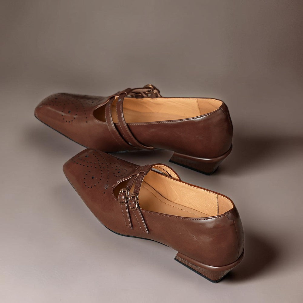 Brown Mary Jane flats with top strap buckle and brogued toe perforations