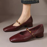 Burgundy leather ballet flats with rounded toe, low block heel, and gold buckle strap