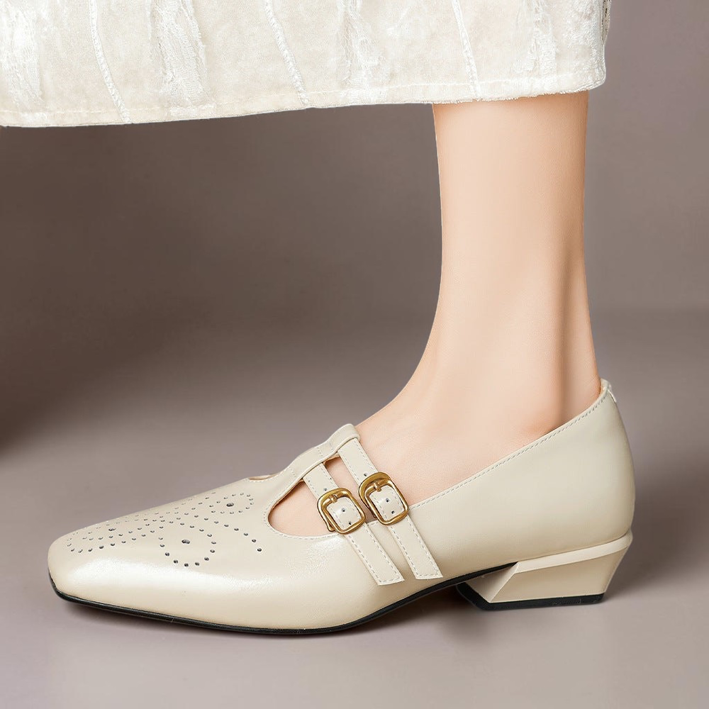 Beige Mary Jane shoes with double buckle straps and broguing details