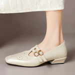 Beige Mary Jane shoes with double buckle straps and broguing details
