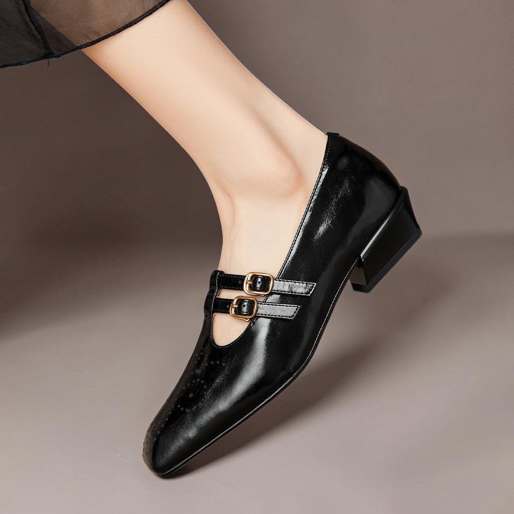 Black Mary Jane flats with buckle strap over vamp, glossy finish, brogue perforations