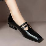 Black Mary Jane flats with two straps, brogue perforations, gold buckles