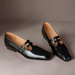 Black Mary Jane flats with two straps and gold buckles, brogue perforations