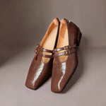 Brown Mary Jane loafers with two straps and buckle details over brogued leather
