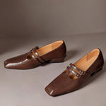 Brown Mary Jane slip-on loafers with double strap buckles and perforated broguing