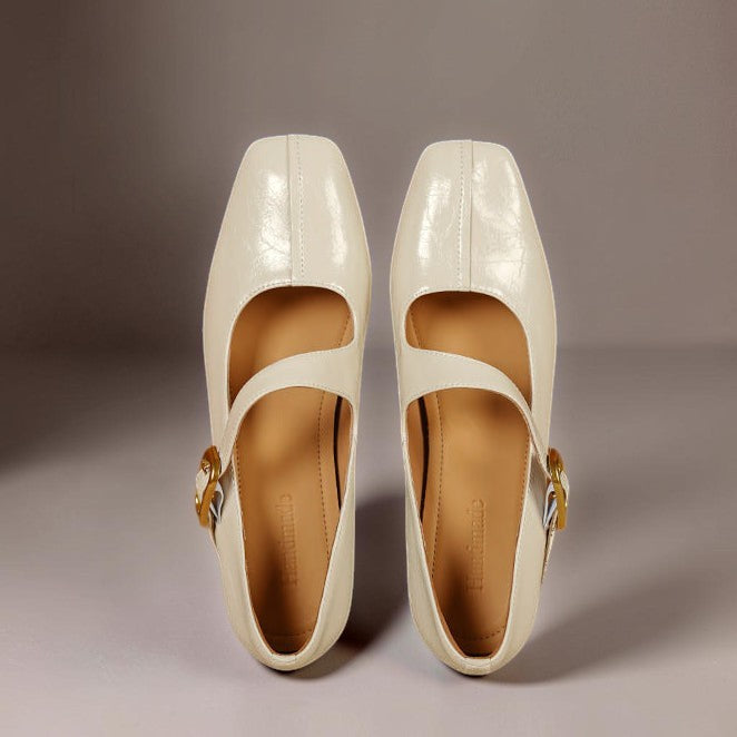 Cream Mary Jane leather flats with gold buckle strap, front close-up