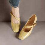 Yellow Mary Jane leather flats with gold buckle strap, on feet with denim