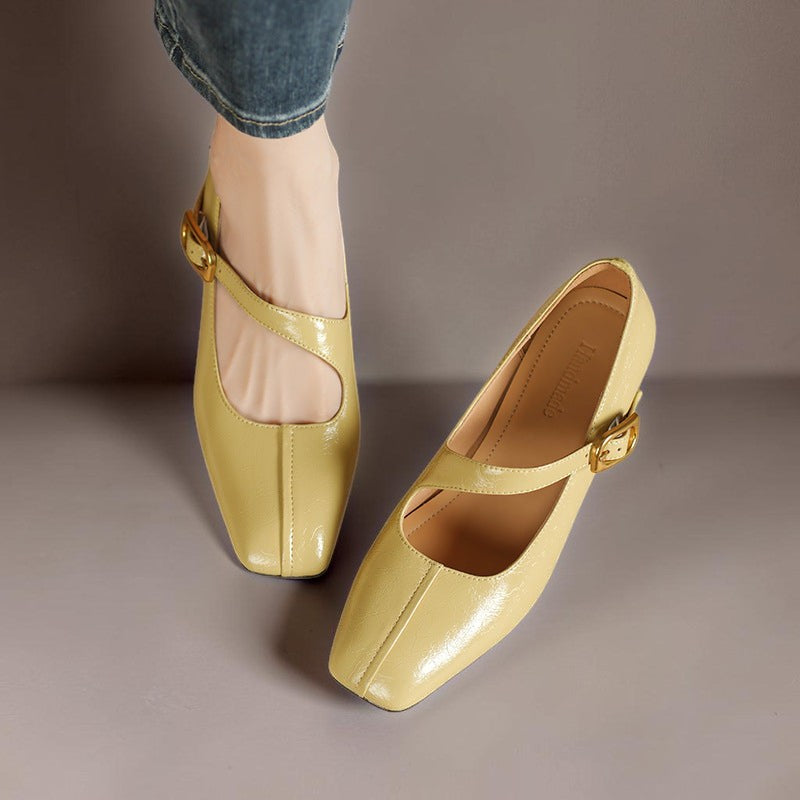 Yellow Mary Jane leather flats with gold buckle strap, on feet with denim