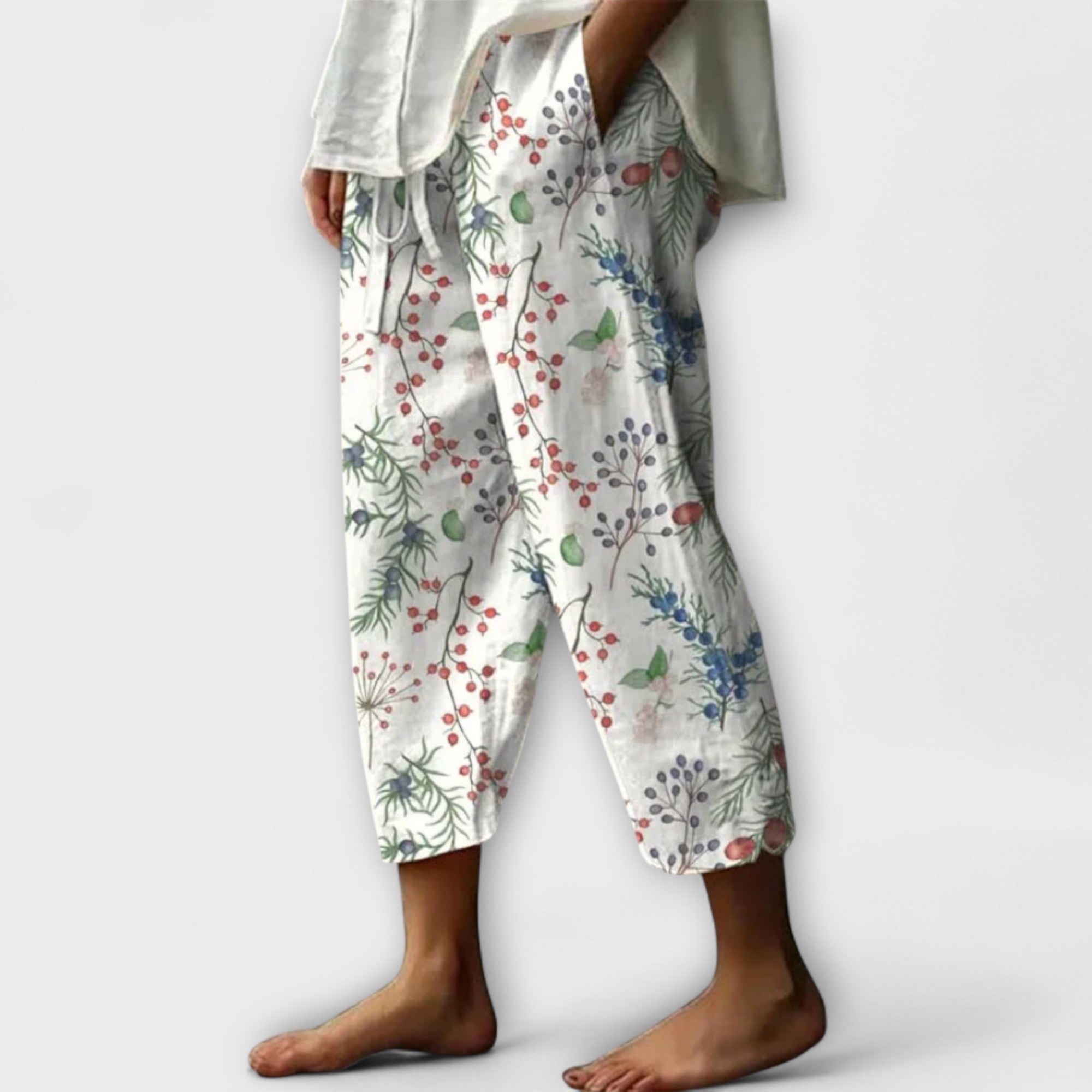 Wide-leg floral printed pants on light background with red berries and blue flowers
