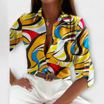 Classic-collar blouse with yellow, blue, and red abstract swirls, button front.