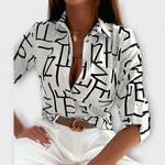 Classic-collar blouse in white with black abstract graphic print, button front.