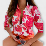 Classic-collar blouse in white with hot-pink ornate floral print, button front.