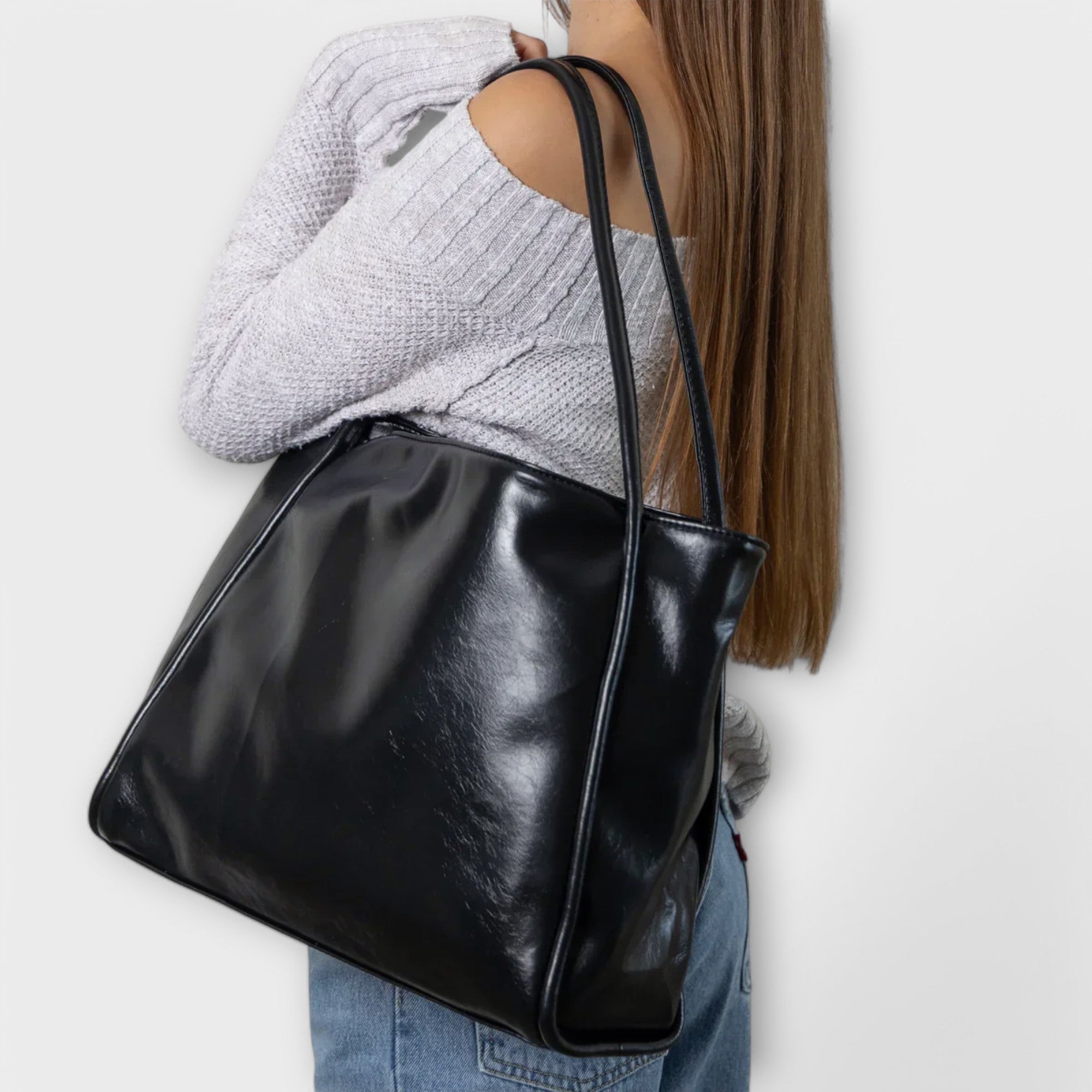 Black leather-look tote bag on model, side view with two top handles