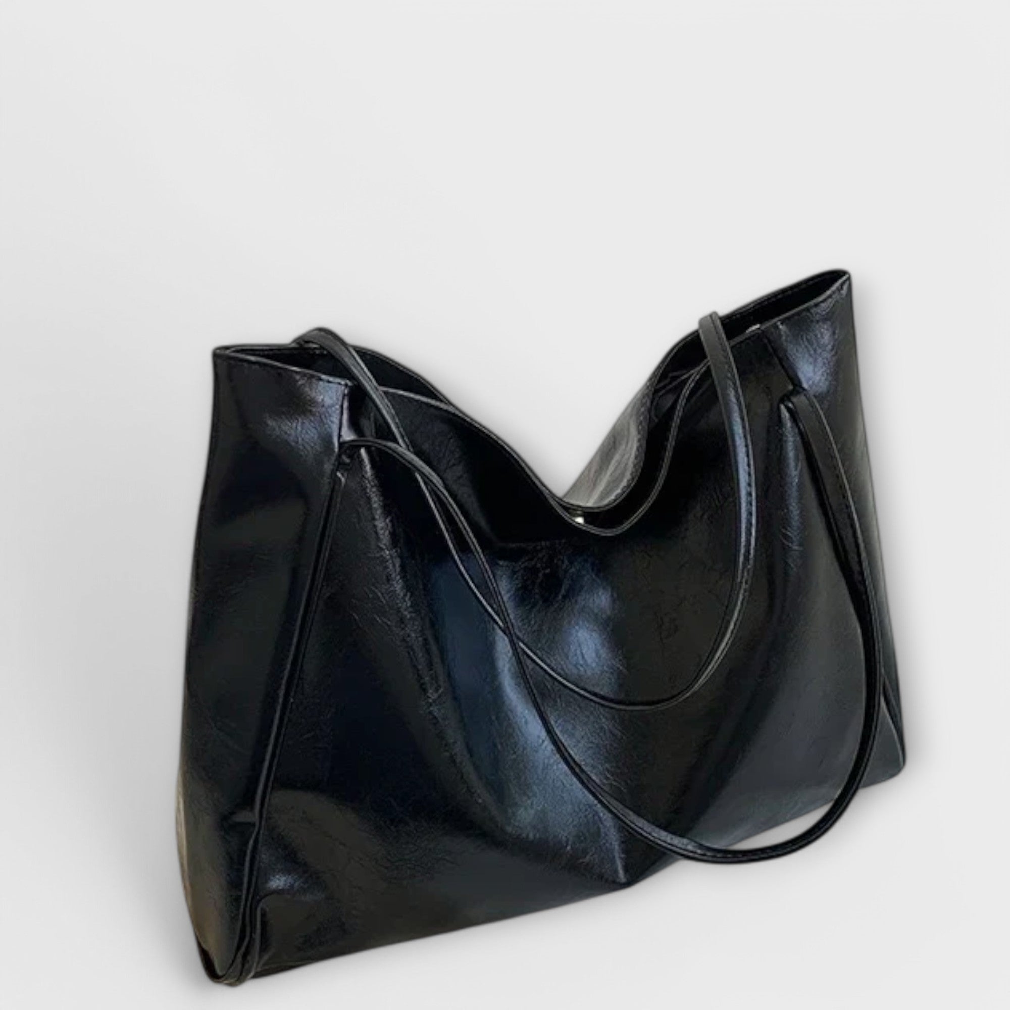 Black leather-look tote bag, angled view with curved double handles